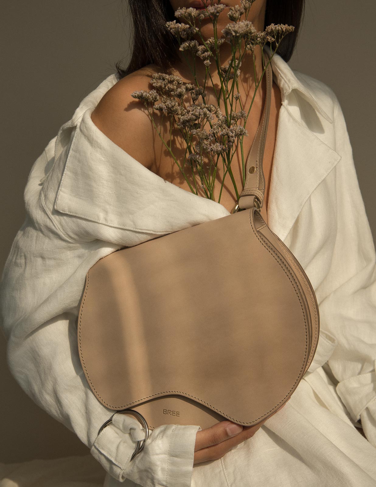 storm wears bree nature bag in the color hummus with a white blanche copenhagen linen coat at Studio230 shot by Marius Knieling