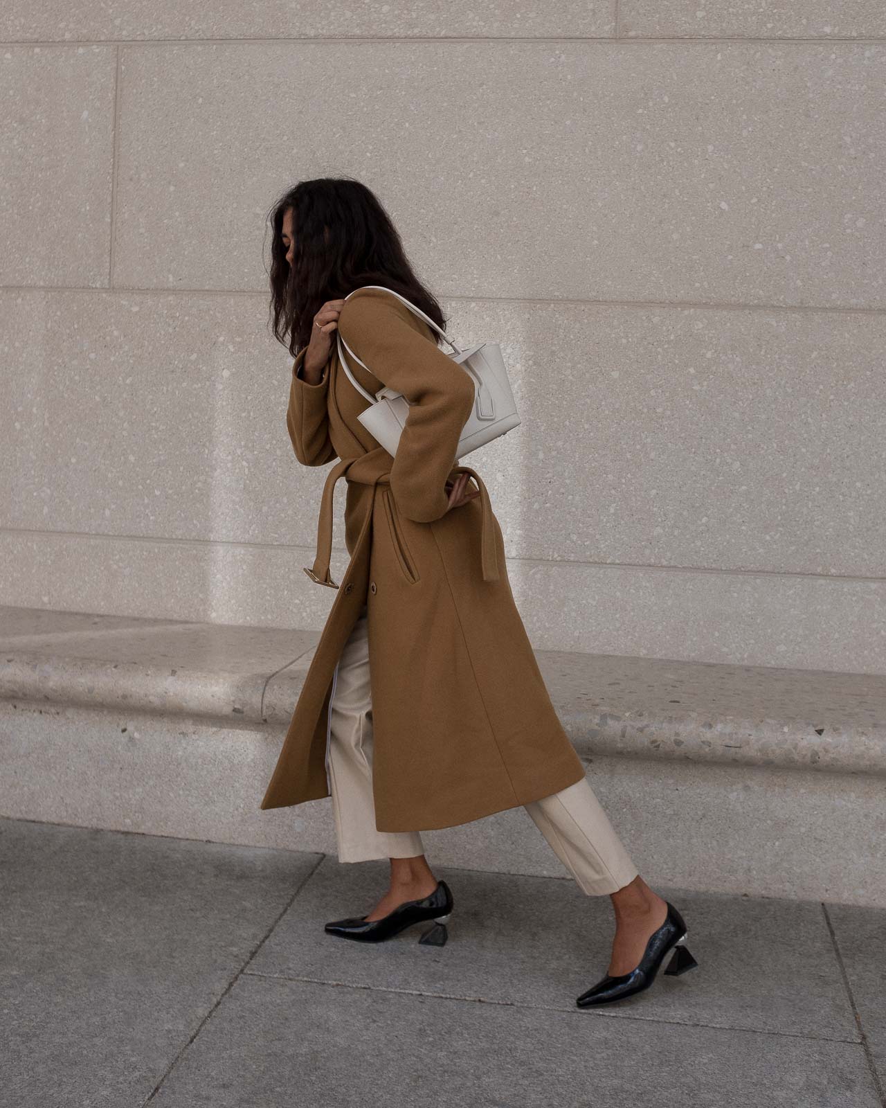 storm wears by malene birger camel coat combined with creme weekday pants and yuul yie black mules 