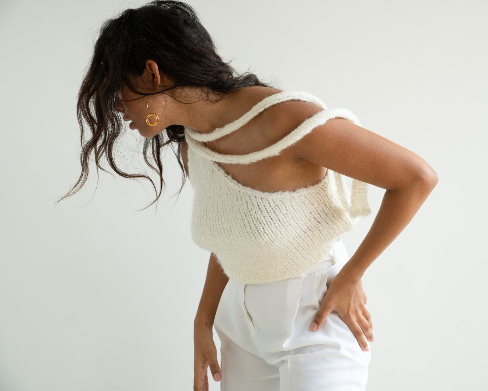 Storm wes wears malaika Raiss white pants combined with knit top and gold earrings detail shot 