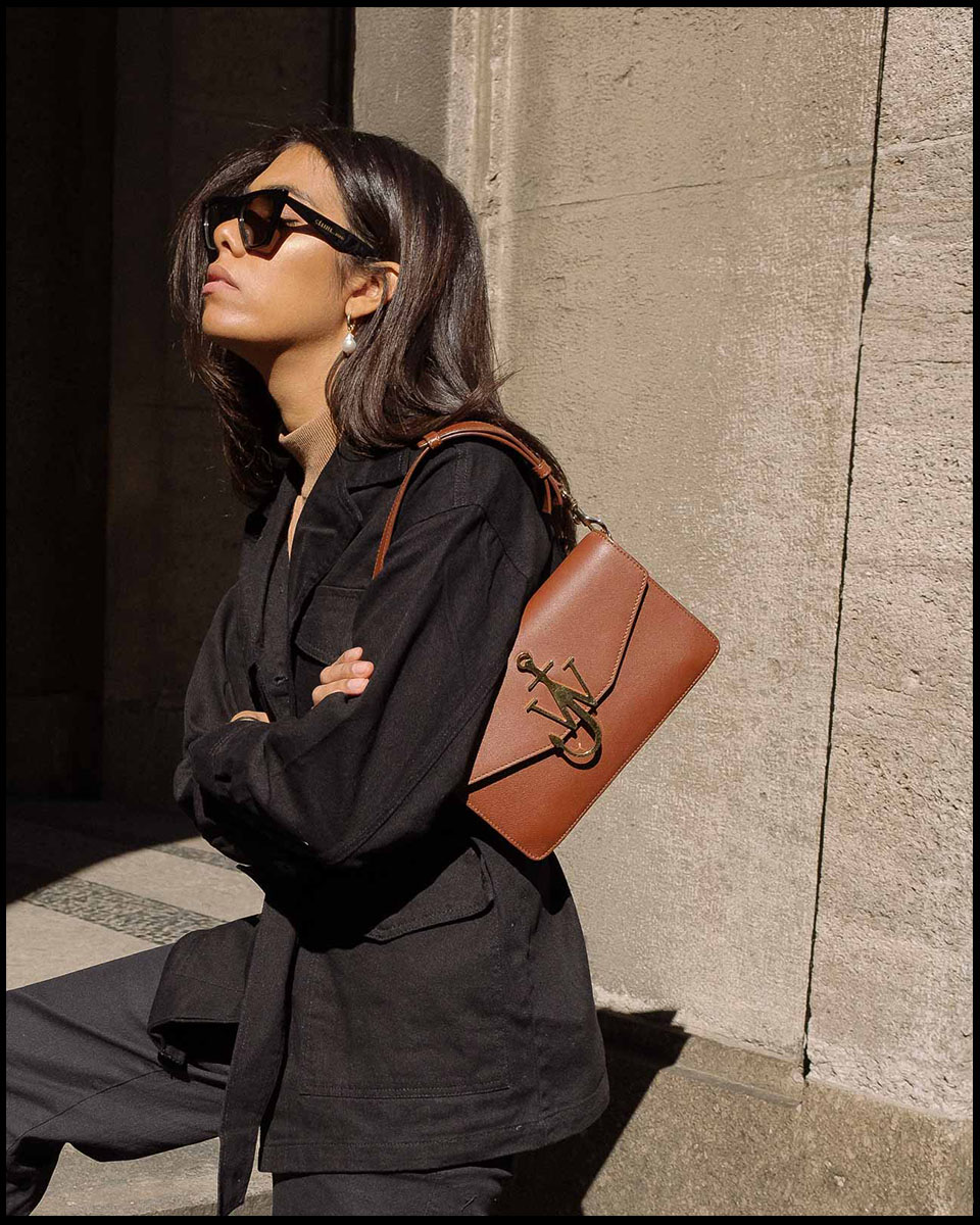 storm wears jw anderson bag with black edited jacket and beige turtleneck with old Céline sunnies