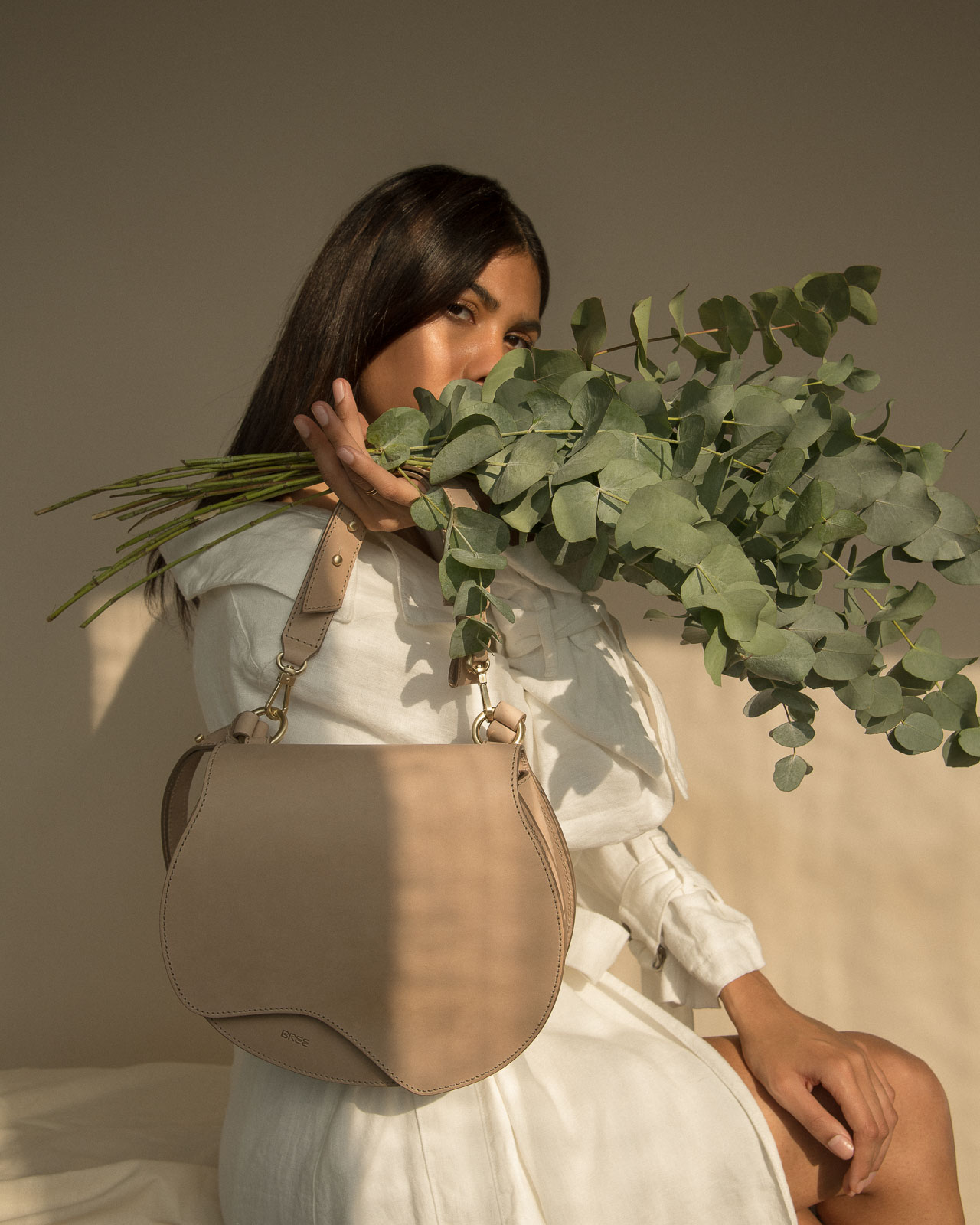 storm wears bree nature bag in the color hummus with a white blanche copenhagen linen coat and eucalyptus at Studio230 shot by Marius Knieling