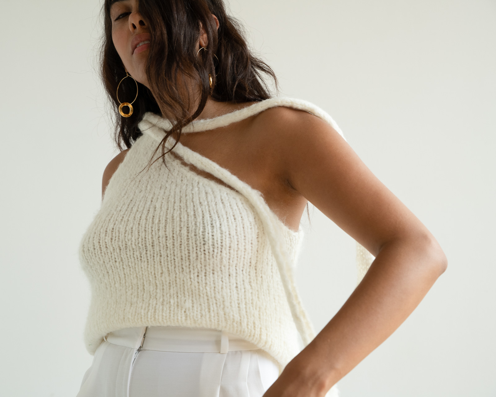 Storm wes wears malaika Raiss white knit top with gold earrings ss20